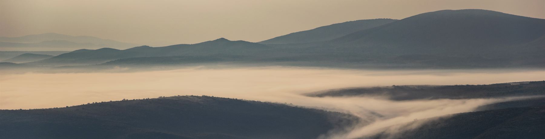 Morning fog in a valley between hills